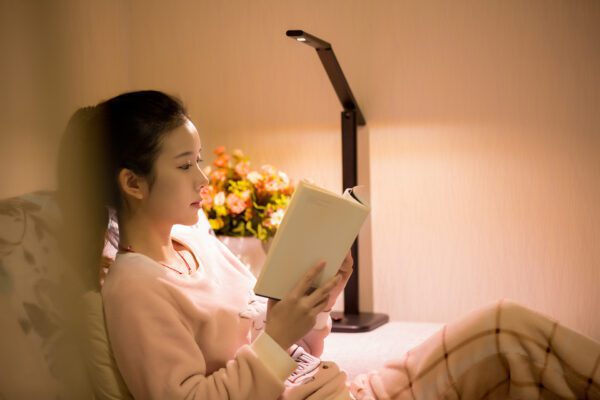 A person sitting on a bed holding a book